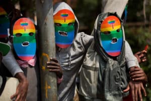 3 activists in protest wearing rainbow masks